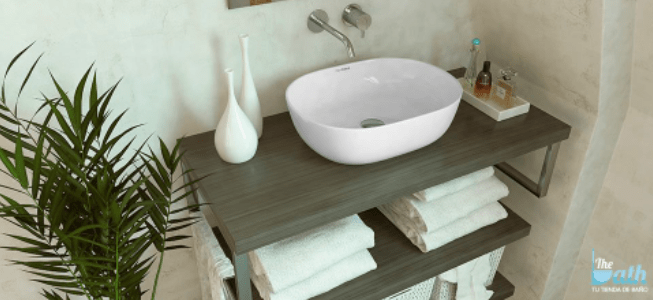 Baño con pila, plantas y toalla